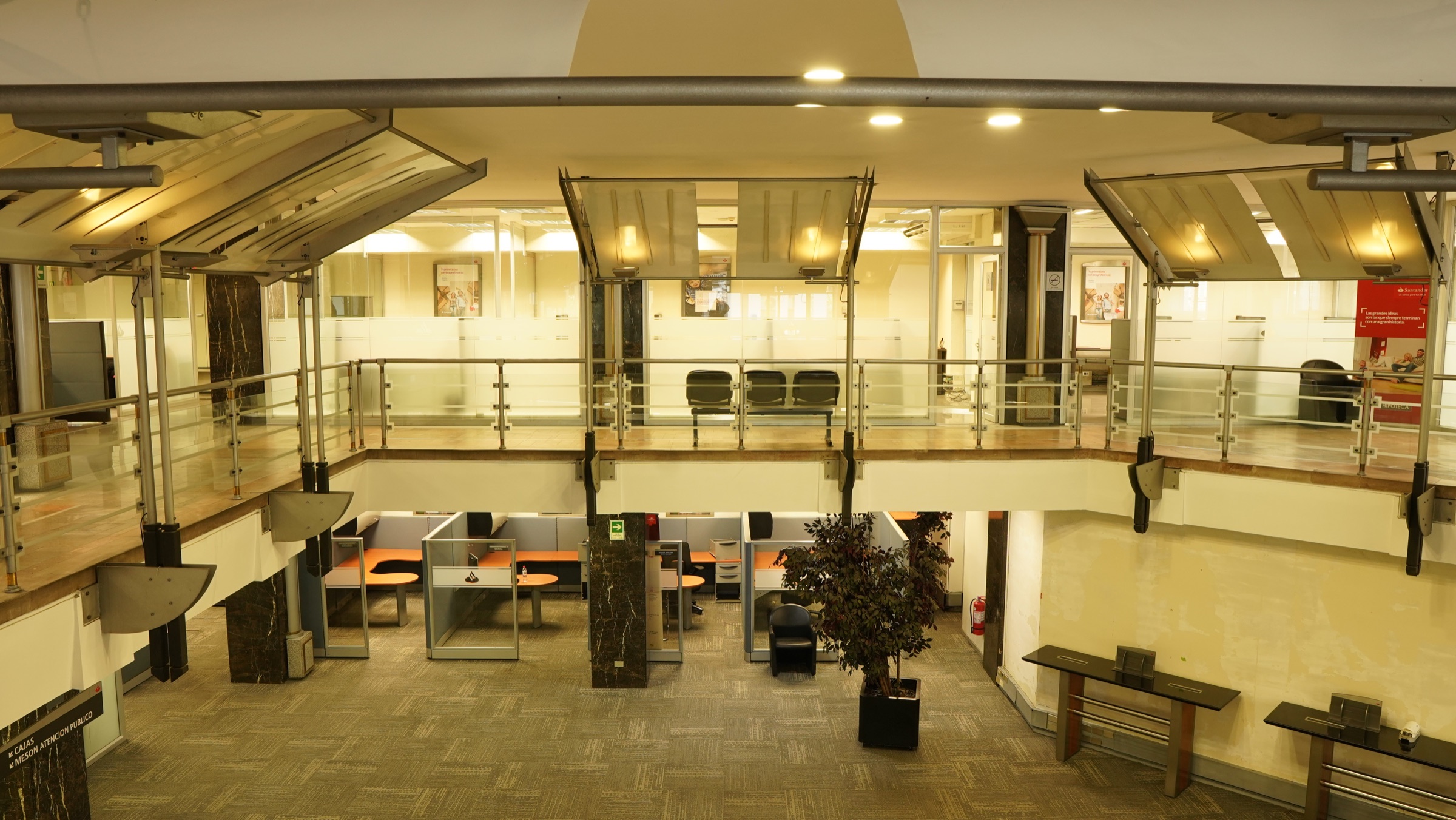 Atrio interior de oficinas Santander con dos niveles y luz cálida