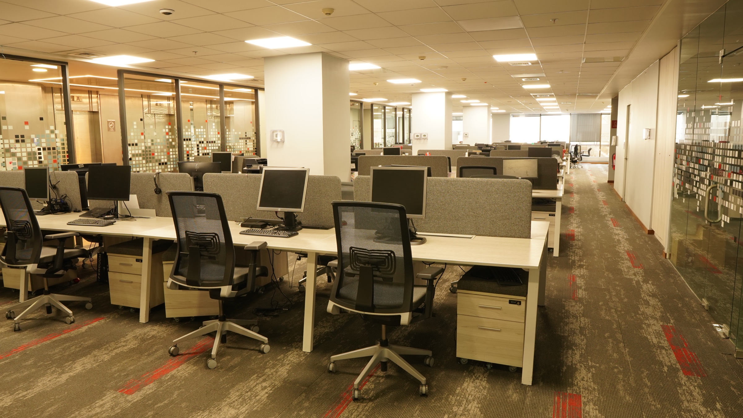 Acceso interior de edificio Santander con recepción y luz cálida